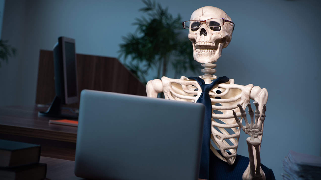 A skeleton sitting behind a laptop for Cybersecurity Awareness Month